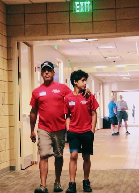 A volunteer and a young participant walk together at a GBSA event