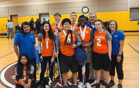 The Atlanta youth goalball team poses with their trophy and coaching staff