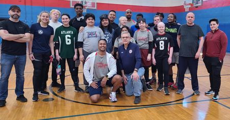 The Atlanta goalball team poses together on the court with coaches and staff