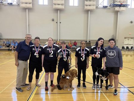 The Atlanta Blazers women's goalball team poses together, including two guide dogs