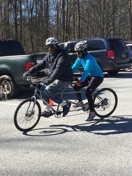 Two tandem cycling riders pose together before a ride
