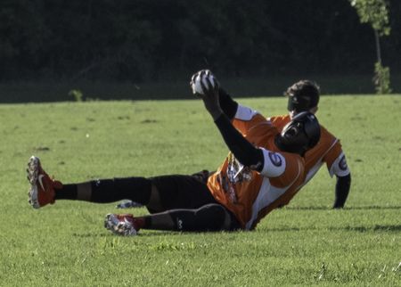 A beep baseball player in an Atlanta jersey slides after making a play