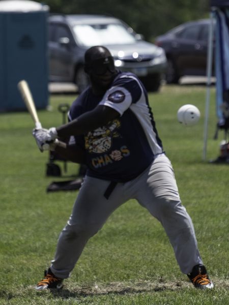 A beep baseball batter for the Chaos swings as the ball flies past