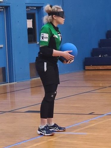 An Atlanta goalball player stretches to block an incoming shot on the court